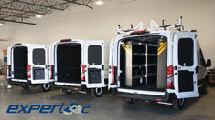 three white vans parked in a warehouse with their doors open and the back door opened