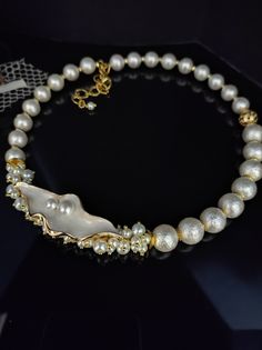 Beautiful choker necklace with white Majorca pearls. The necklace is in the classic 50s style and gives a touch of refined elegance to your look. The necklace is made with rough Majorca pearls, they are pearls with a glass heart and covered with shell substance, they have a perfect round shape and are very bright. The necklace has an adjustable lobster clasp with a 6cm extension. The necklace is asymmetrical thanks to the enamelled leaf component which gives a romantic and refined touch. The necklace is twisted, holds its shape perfectly but at the same time sits perfectly on the neck. This type of necklace is very versatile, suitable for every day but at the same time it is perfect for an evening dress for a special occasion. This pearl necklace cannot be missing from your jewelry collect Elegant White Pearl Charm Choker, Elegant White Choker With Pearl Charm, Formal Pearl Choker With Pearl Charm, Formal Pearl Choker With Pearl Drop, Elegant White Choker With Pearl Drop, Formal Pearl Drop Choker, Elegant White Pearl Drop Choker, White Pearl Charm Choker For Party, Elegant Pearl Charm Choker For Formal Occasions