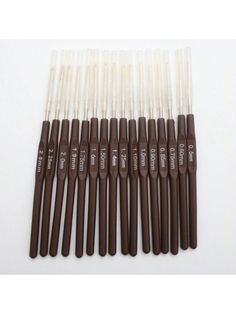 six brown and white brushes are lined up in a row