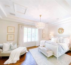 a bedroom with white furniture and chandelier