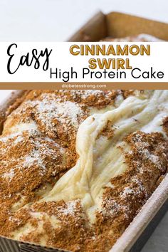 an easy cinnamon swirl high protein cake in a pan with powdered sugar on top