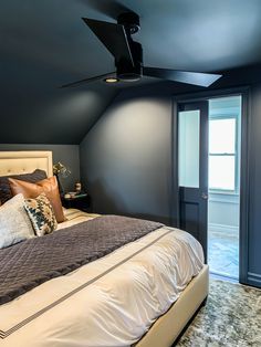 a bedroom with blue walls and white bedding has a ceiling fan in the corner