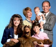 the family is posing for a photo with their dog and baby in front of them