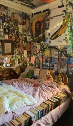 a bed with lots of books on top of it in a room filled with pictures