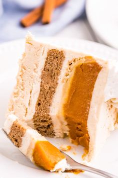 a piece of cake on a white plate with a fork in front of the slice