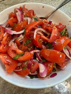 a white bowl filled with sliced tomatoes and onions