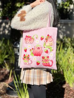 Overview: Cotton Tote Bag: -34 x 38 cm(B x H). -13.4 x 15 in(B x H). -Inner Pocket. -Zipper at the mouth of the bag. -Single-sided heat press print. -Rare pink color. This beautiful handmade tote bag is made of premium quality, pink cotton, and features a full of cute strawberry cat print. The bag is designed with functionality in mind, featuring a secure zipper closure and a small inner pocket, perfect for keeping your essentials organized. The bag is also made with heat transfer technology, en Kawaii Cat Design Tote Bag, Kawaii Cat Design Shoulder Bag For Daily Use, Kawaii Tote Bag With Cat Design, Kawaii Shoulder Bag With Cat Design For Daily Use, Kawaii Cat Design Bag For Everyday Use, Casual Pink Bag With Animal Design, Everyday Pink Bag With Cat Design, Cute Pink Cat Design Bag, Cute Pink Bag With Cat Design