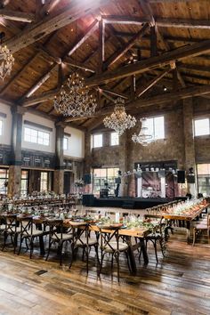 a large room with tables and chandeliers on the ceiling is set up for an event