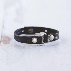 Our Do Good Bracelet is handcrafted with the softest lamb leather and detailed with a rounded D-ring and large flat rivets. This bracelet can be worn alone or stacked with your favorite Giving Bracelet! FEATURES Handcrafted - Each Bracelet is delicately handcrafted. Finest Leather Available - We use lamb leather to achieve a much softer feel than cow leather. Makes The World a Better Place - The heart of our business is giving back and we are honored to be partnered with Voices for CASA Children Adjustable Leather Bracelet With Snap Closure, Adjustable Black Leather Cuff Bracelet, Adjustable Cuff Bracelet With Wrist Strap For Everyday, Adjustable Wrist Strap Cuff Bracelet For Everyday, Classic Adjustable Leather Bracelet, Adjustable Cuff Leather Bracelet For Everyday, Adjustable Leather Cuff Bracelet For Everyday, Classic Adjustable Leather Bracelet With Wrist Strap, Adjustable Classic Bracelet