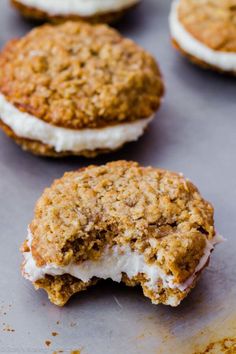 several cookies with white frosting and crumbs sitting on top of a baking sheet