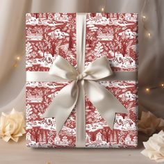 a gift wrapped in red and white paper with a bow