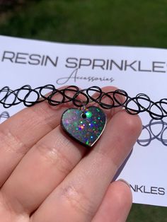 Each resin pendant is handmade to order, therefore no two chokers are identical! However, I try to get as close to the listing photos as possible :) One size fits all black elastic choker necklace. Heart width is approximately 19mm and is made with epoxy resin, black liquid color pigment, and white chunky holographic glitter ✨ Thanks for visiting my shop! 🖤 Grunge Necklace For Valentine's Day Gift, Grunge Heart-shaped Necklace For Gifts, Trendy Heart Charm Choker As Gift, Trendy Heart Pendant Choker For Gift, Trendy Heart Pendant Choker As Gift, Trendy Iridescent Jewelry For Gifts, Nickel-free Black Choker As A Gift, Handmade Grunge Jewelry For Festivals, Handmade Grunge Jewelry For Gifts