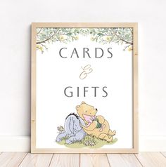 a winnie the pooh card and gift sign on a wooden floor next to a white wall