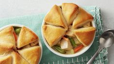 two bowls filled with food on top of a green towel next to a spoon and fork