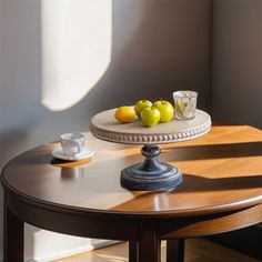 two lemons on a table with some cups and saucers next to each other