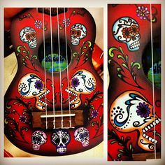 a red ukulele with skulls painted on it