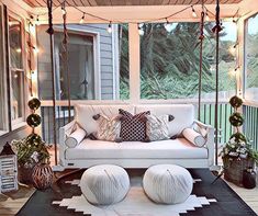 the porch is decorated with white furniture and string lights