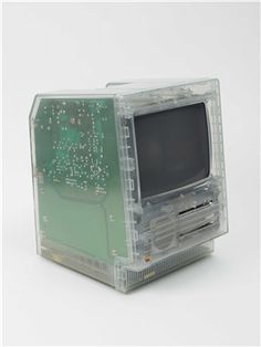 an old computer that is sitting on a white surface, with the screen removed from it's housing