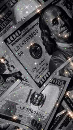 many hundred dollar bills with sparkles on them