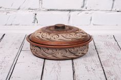 an old wooden box sitting on top of a white wood floor next to a brick wall