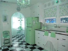 a green refrigerator freezer sitting inside of a kitchen next to a checkered floor