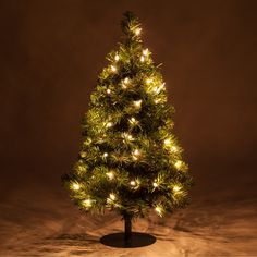 a lit up christmas tree sitting on top of a table