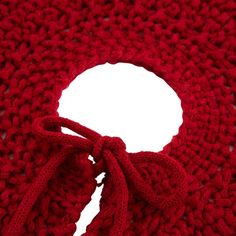 a red knitted scarf with a knot at the end and a white circle in the middle