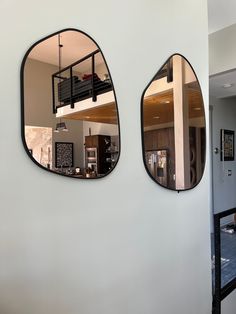 there are two mirrors on the wall in this room, one has a staircase to the second