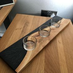 three shot glasses sitting on top of a wooden table