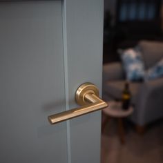 an open door with a handle on it in front of a living room chair and ottoman