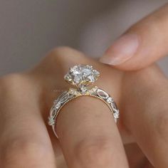 a woman's hand holding an engagement ring with two diamonds on the top and bottom