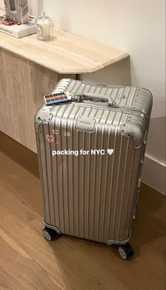 a silver suitcase sitting on top of a hard wood floor