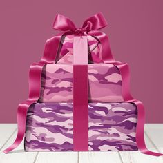 three boxes with pink and purple camouflage designs on them, tied up in ribbons to the top