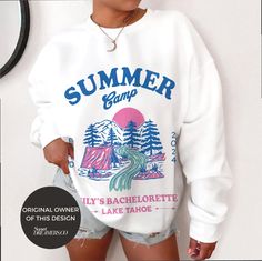 a woman wearing a white sweatshirt with the words summer camp printed on it