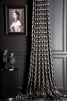 a black and white curtain hanging in front of a painting