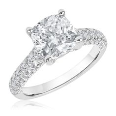 a cushion cut diamond engagement ring with pave set diamonds on the shoulders and sides