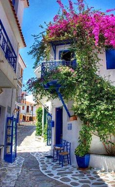 an image of a house with flowers on the outside and blue doors in the front