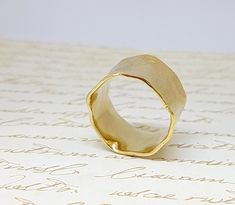 a gold ring sitting on top of a piece of paper