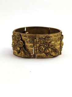 Vintage MCM bracelet in brass with flowers and leaf design. 1960's. The bracelet is in good vintage condition. Measures about 7 inches and about 1 1/4 inches wide. Please visit our Etsy store for similar items at http://www.etsy.com/shop/MarleysOnMain As with all vintage and antique jewelry, this is a previously used piece and will show some signs of wear. Please review our shop policies.Jewelry Vintage jewelry Vintage Metal Bracelets For Weddings, Antique Bronze Bracelet For Wedding, Antique Gold Bracelet With Antique Finish, Vintage Brass Bracelet With Intricate Design, Vintage Bronze Bracelets For Formal Occasions, Vintage Metal Bangle For Wedding, Vintage Bronze Bracelet For Formal Occasions, Vintage Bronze Bracelets For Wedding, Vintage Gold Bracelets For Ceremonial Occasions