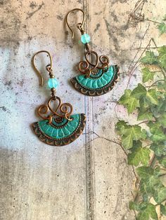 "Beautiful, hand-crafted embossed copper earrings with an oxidized patina in shades of green, blue and copper.  Swirled, hammered copper wire, aqua blue chalcedony gemstone beads & copper beads, along with my hand-made copper ear wires, complete the design.    Overall earring length is 2.5\". These Bobo beauties are really cool, lightweight, and so much fun to wear." Blue Artisan Copper Earrings, Artisan Blue Copper Earrings, Artisan Turquoise Earrings In Copper, Artisan Turquoise Copper Earrings, Vintage Copper Earrings With Patina, Bohemian Blue Copper Earrings, Handmade Turquoise Earrings With Copper Wire, Bohemian Copper Earrings With Patina, Bohemian Jewelry In Copper Wire With Patina