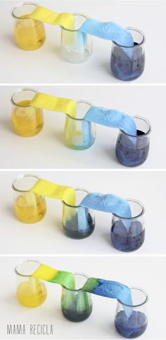 four different colored glass vases with one being filled with liquid and the other is empty