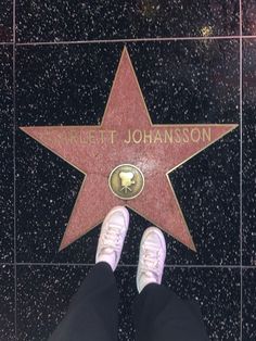 a person standing in front of a star on the hollywood walk of fame with their feet up