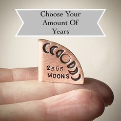 a hand holding a small piece of metal with the words choose your amount of years on it