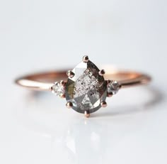 a white diamond ring with three diamonds on the top and one stone in the middle