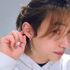 a person wearing ear rings and a white shirt