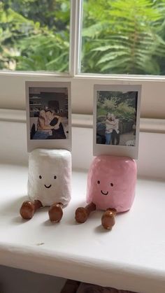 two marshmallows sitting next to each other on a window sill