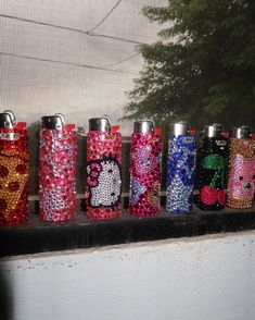 a row of colorful flasks sitting on top of a window sill