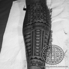 a black and white photo of a man's leg with an intricate tattoo design on it