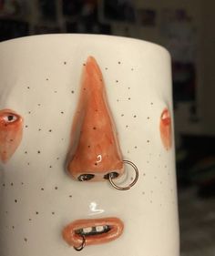 a close up of a coffee cup with a face on it