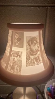 a lamp that has pictures of dogs on the lampshade and is lit up